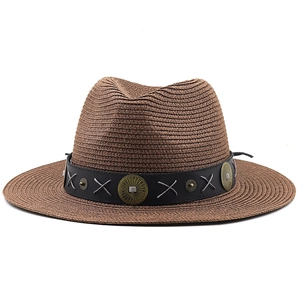 Detail of bohemian dark brown straw fedora with vintage metal concho leather band