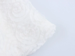 Detailed macro view of white mesh fabric featuring 3D rose floral texture and patterns