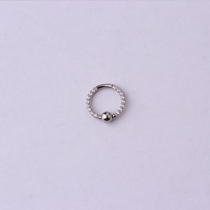 Gros plan d'un anneau de piercing en C en acier inoxydable argenté avec zircone et bille