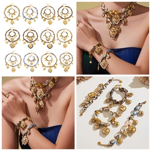 Dettaglio di collane con pendente a cuore d'oro e bracciali in seta in vari motivi