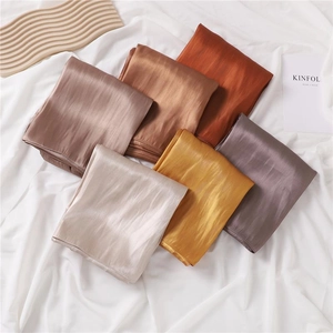Detailed macro view of six colorful satin scarves with a glossy silk-like finish and texture