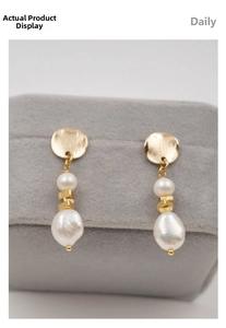 Close-up of elegant baroque pearl earrings with gold brushed metal on velvet jewelry box