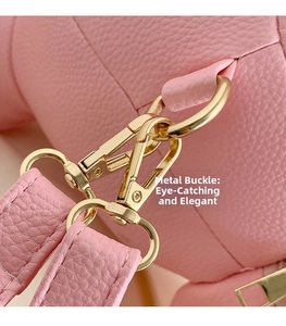 Detailed close-up of premium light gold metal buckle on pink litchi grain leather bag