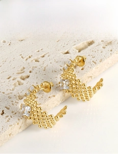 Détail de boucles d'oreilles dorées en C avec zircons carrés et motif perlé
