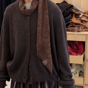Detail of dark brown cardigan styled with a vintage paisley printed silk scarf
