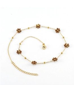 Detailed shot of golden flower anklet with brown petals and adjustable lobster clasp