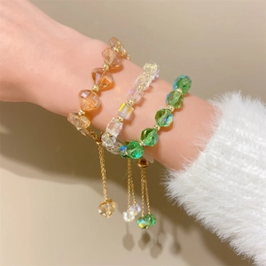 Detail of faceted amber and emerald crystal bead bracelets with adjustable pull chains