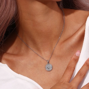 Detailed view of silver compass pendant necklace with zircon stone on model