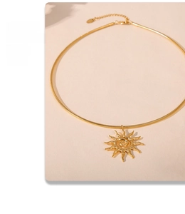Close-up of golden sun pendant with spiral texture on high-quality snake chain necklace