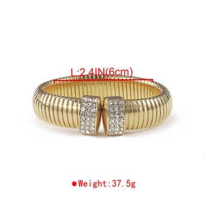 Detail of gold-plated bangle with textured surface and pavé zircon rectangular ends