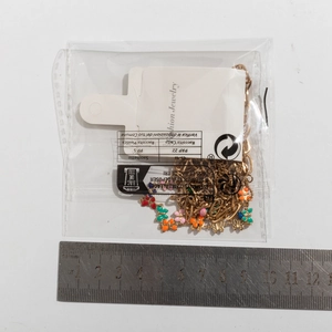 Detailed close-up of colorful butterfly charm necklace with measuring tape for size guide