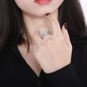 Detail of silver heart ring with watch band chain structure worn on finger