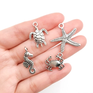 Set of four silver ocean life charms including turtle starfish seahorse and crab