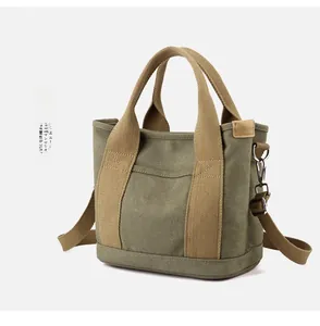 Detail view of durable canvas bag with reinforced handles and secure metal shoulder strap hooks