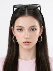Close-up of oversized silver double hoop earrings with a polished metallic finish