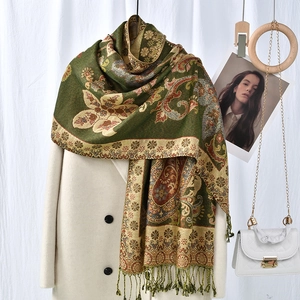 Detailansicht eines grünen Paisley-Schals mit gelben Blumen und dekorativen Vintage-Fransen