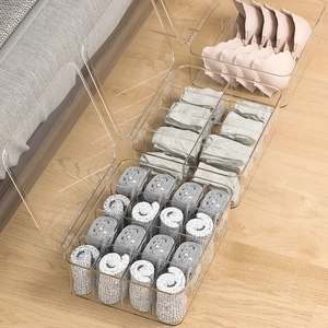 Clear drawer organizers with lids for socks and underwear on a wooden floor