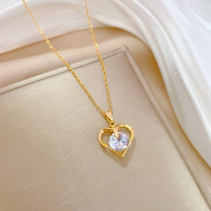 Luxurious gold heart pendant necklace with round zircon stone on soft silk background
