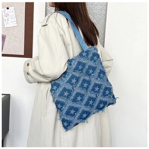 Side view of a vintage denim tote bag with frayed edges and printed stars on model