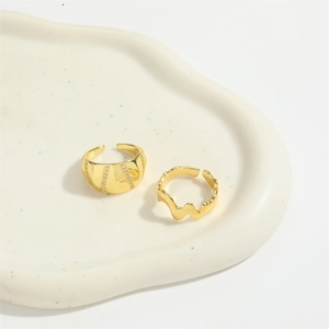 Minimalist gold adjustable rings set featuring wavy design and crystal stripes in a tray