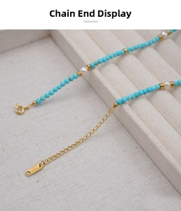 Detail of golden extender chain and K18 hallmark on turquoise and pearl beaded necklace