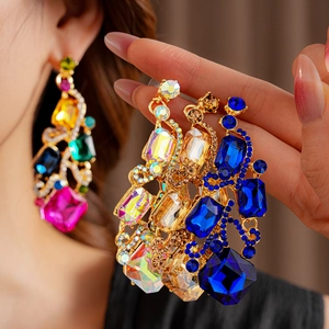 Close-up of vintage gold square earrings with colorful rhinestones on a model