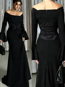 Front and back view of black off-the-shoulder evening gown with mermaid tail and bell sleeves