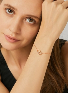 Close-up of rose gold interlocking double circle bracelet with sparkling white zircons