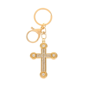 Detailed view of a gold cross keychain with sparkling crystals on a clean white background