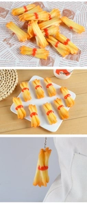 Detailed view of realistic PVC French fry keychain attached to a white canvas bag