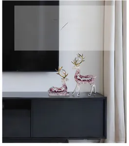 Detail of creative resin deer sculptures with purple crystal filling and golden antlers