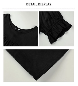 Détails d'une robe noire à col rond avec manches à volants et tissu texturé