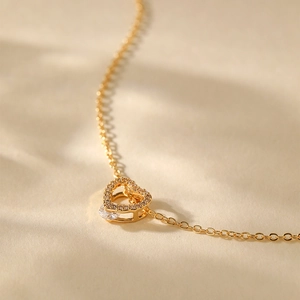Macro shot of 18K gold plated heart pendant with sparkling zircons on a delicate O-chain