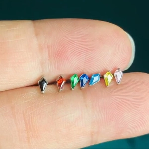 G23 titanium kite shaped zircon labret studs in 7 colors held between fingers