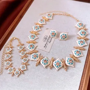 Vintage palace style jewelry set with white enamel diamond shapes and blue floral patterns