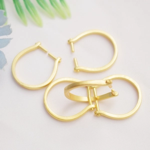 Macro shot of 14K gold-plated C-shaped leaf ring settings with matte metal texture