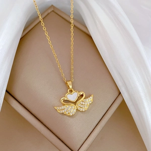 Detail of gold swan heart pendant with shell stones and sparkling crystals on silk