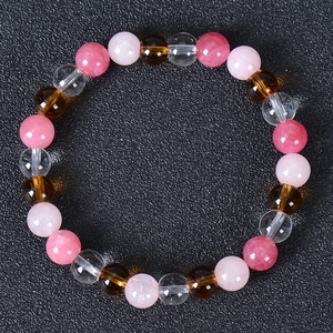 Macro detail of multi-colored natural stone beads including pink quartz and crystal