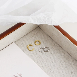Close-up of gold and silver S925 sterling silver hoop earrings with hammered texture
