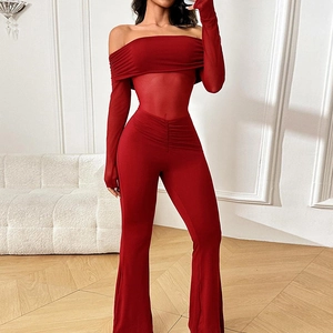 Detail eines roten schulterfreien Jumpsuits mit Mesh-Einsätzen und ausgestellten Ärmeln