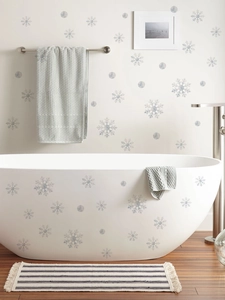 Detail of white snowflake window stickers displayed on a modern bathroom wall