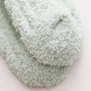Close-up of soft mint green coral fleece material on thick thermal winter socks