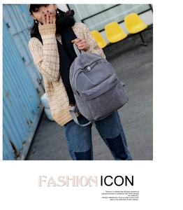 Gray corduroy backpack with front pocket styled on a model against a blue background