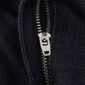 Dettaglio del tessuto denim blu scuro di alta qualità e della cerniera metallica robusta