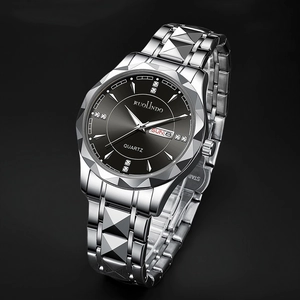 Macro detail of silver quartz watch with diamond markers and dual calendar display
