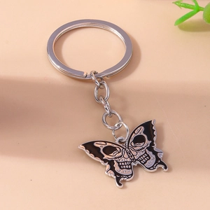 Close-up of gothic butterfly keychain with skull patterns and black enamel finish