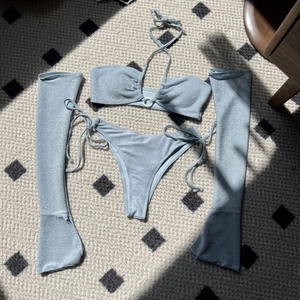 Detailed flat lay of light blue four-piece glitter bikini set with flare sleeves