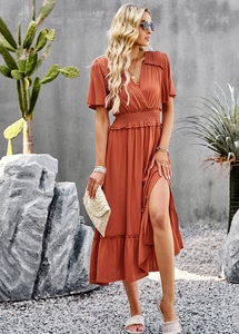 Detail view of rust-red V-neck maxi dress showing elastic waist and side slit features