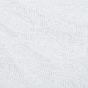 Close-up of white textured fabric showing delicate pleated details and woven surface