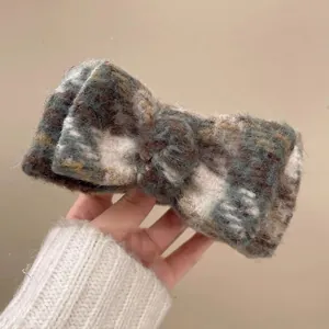 Detail shot of the plush plaid bow hair claw clip showing soft fabric texture and pattern